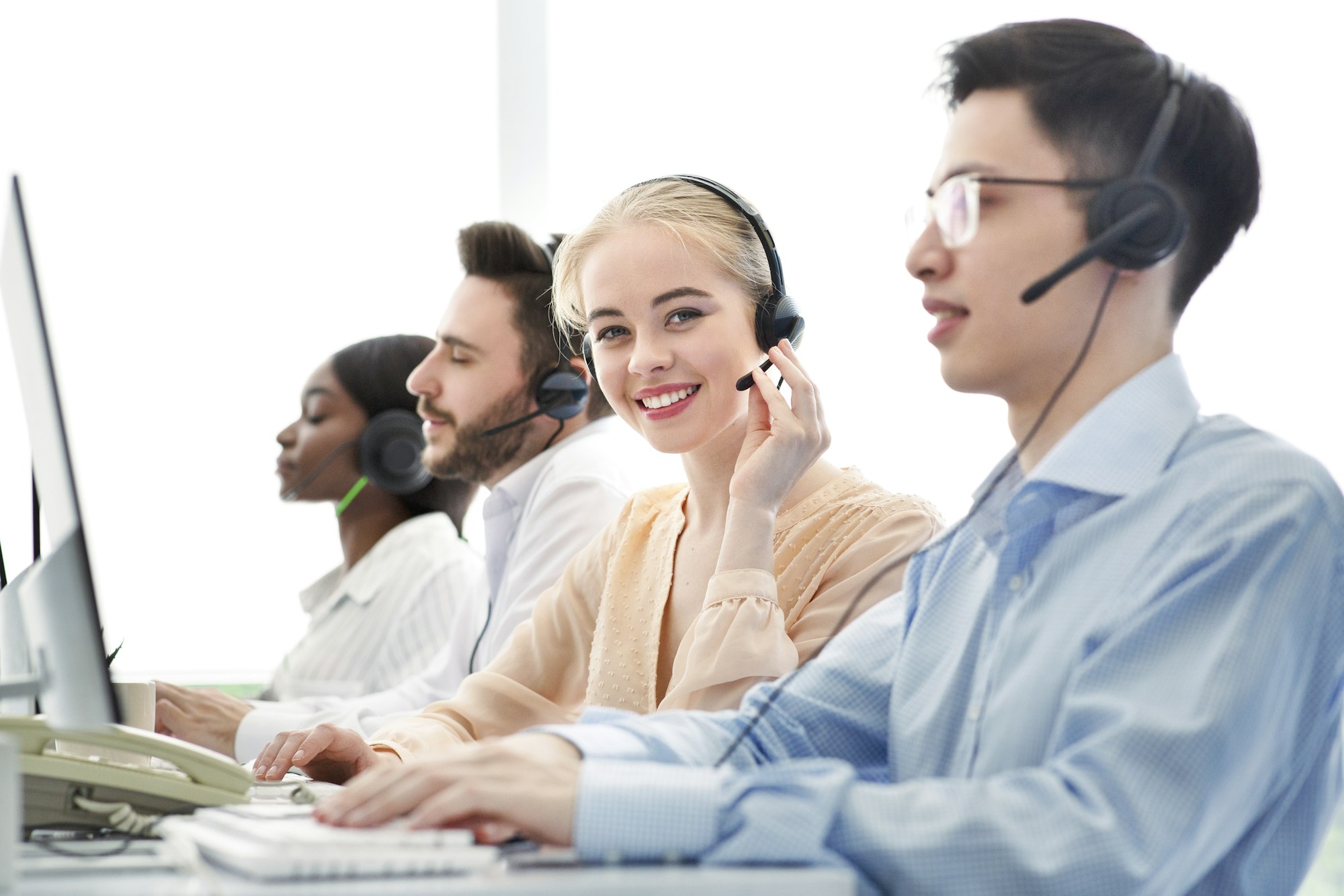 Telemarketing concept. Happy hotline operators selling goods or services through VoIP telephony at